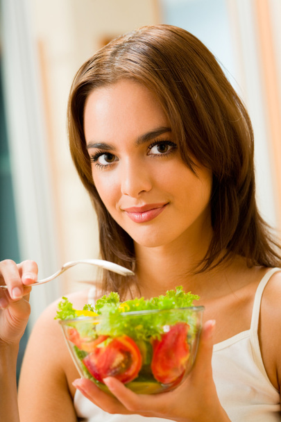 Young happy smiling woman with salad at home - Foto, afbeelding