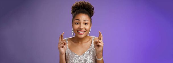 Veselá optimistická okouzlující africká americká přítelkyně. podpora přítel, aby přání chtějí vyhrát první cenu kříž prsty štěstí s úsměvem široce nosit třpytivé stříbrné šaty předjímající štěstí. - Fotografie, Obrázek