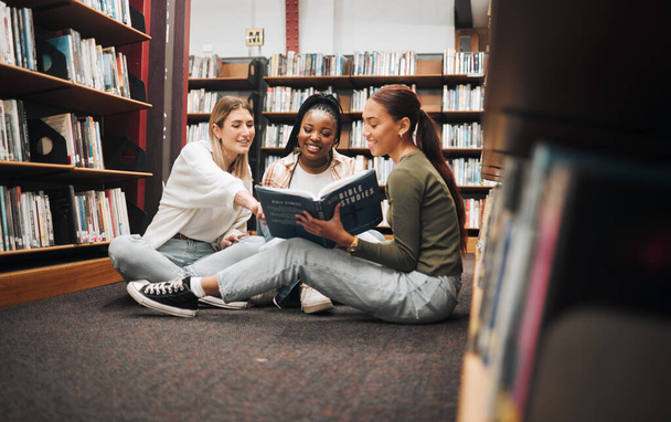 Üniversite, kütüphanede kitapları olan öğrenciler ve kadınlar grup araştırma projesi için araştırma yapıyor ve bilgi topluyor. Üniversite, öğrenci çeşitliliği ve birlikte ödev yapan arkadaşlar.. - Fotoğraf, Görsel