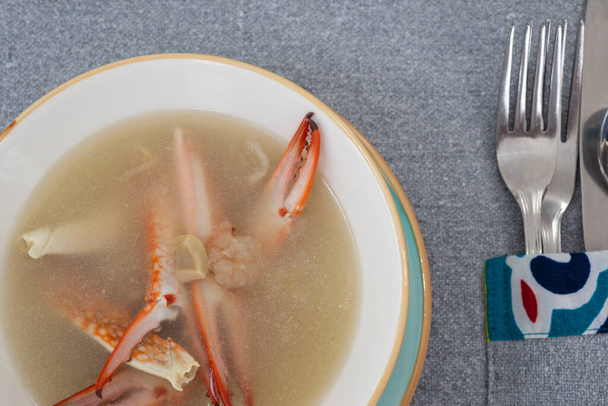 Крупный план супа из крабовых морепродуктов а ля карт закуска в миске с столовыми приборами в ресторане - Фото, изображение