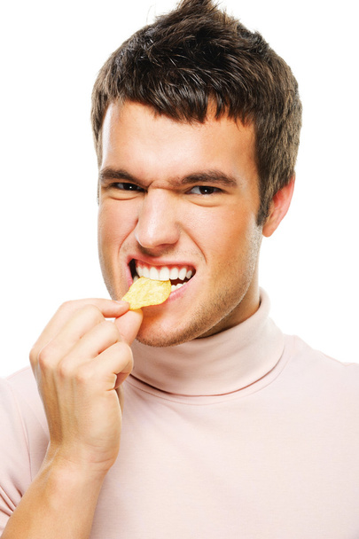 Portrait of young man eating chips - Photo, Image