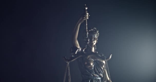 Derecho legal, abogado de patentes o concepto de abogado exitoso. Estatua de bronce de themis o dama de justicia sobre fondo negro - Imágenes, Vídeo