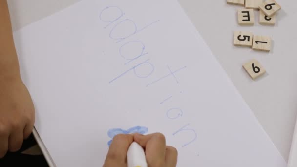Word ADAPTIE geschreven door een kind op een papier. Hoge kwaliteit 4k beeldmateriaal - Video