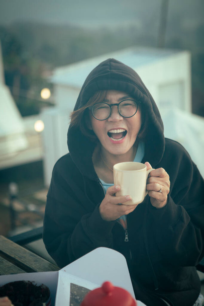 γυναίκα με χαρούμενο πρόσωπο κρατώντας τον καφέ στο χέρι  - Φωτογραφία, εικόνα