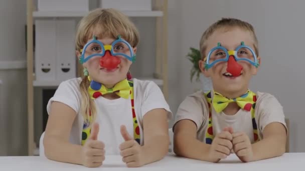 Jongen en meisje zijn gekleed in clownjurk met rode neuzen. Rode neus Dag. Hoge kwaliteit 4k beeldmateriaal - Video