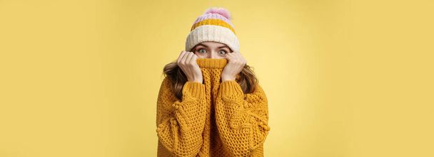 Lifestyle. Charming playful charismatic girl hiding face pull sweater collar nose widen eyes surprised happy fool around having fun enjoying winter vacation mountains escape cold wearing warm clothes. - Photo, Image