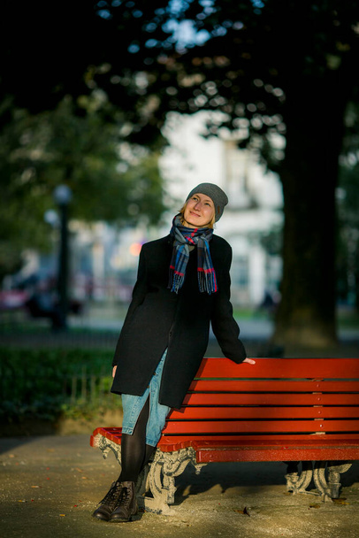 Žena v podzimním kabátě, šále a čepici v útulném parku - Fotografie, Obrázek