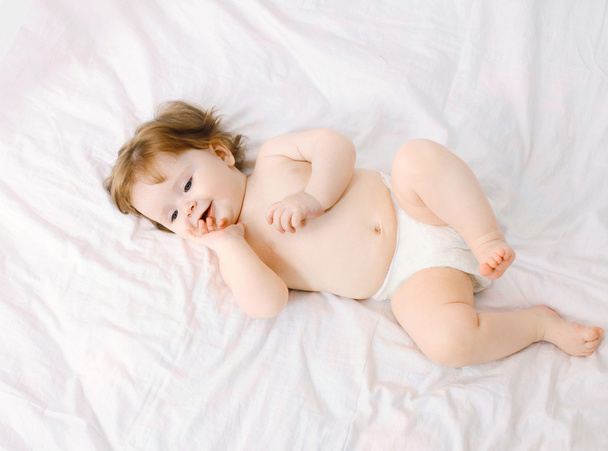 Sweet baby lying on the bed at home, top view - Foto, immagini