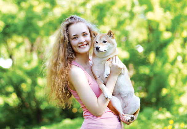 sonniges Porträt charmantes hübsches Mädchen und ihr liebenswerter Hund im Freien  - Foto, Bild