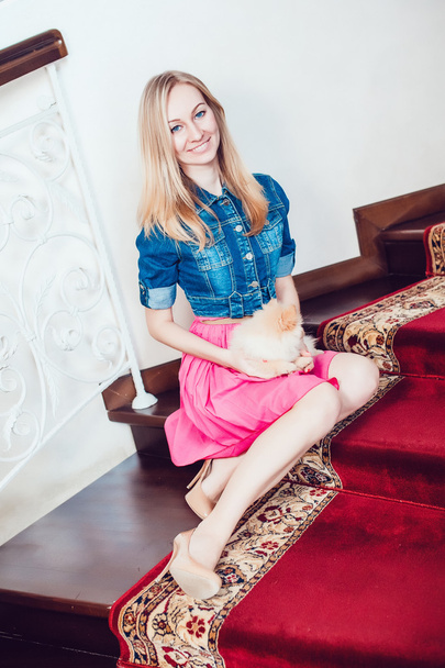 Beautiful Blonde Woman with Her Dog in a Beautiful Interior - Фото, изображение
