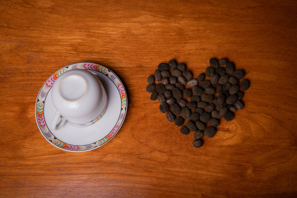Tasse de café avec grains de café fraîchement cueillis formant un cœur - Photo, image
