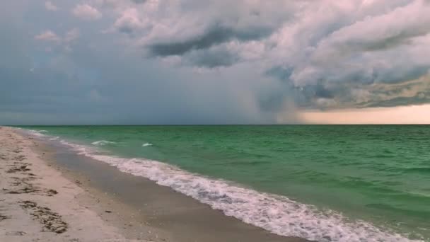 Donkere stormachtige wolken vormen zich op sombere hemel tijdens zware regenseizoen boven de zee beuken oppervlak in de avond. - Video