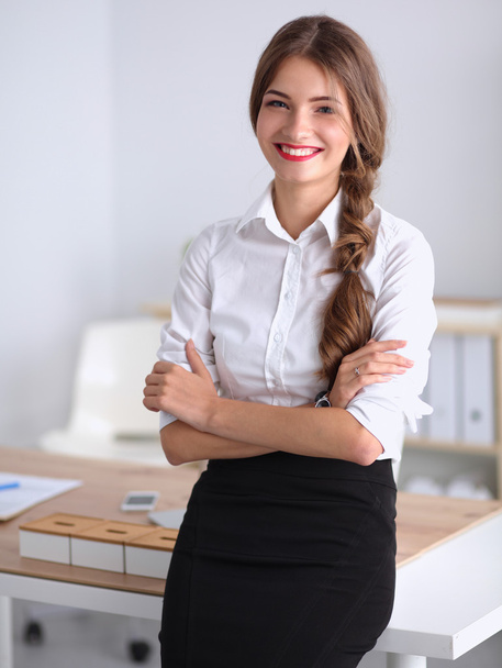 Attractive businesswoman with her arms crossed  standing in office - Фото, изображение