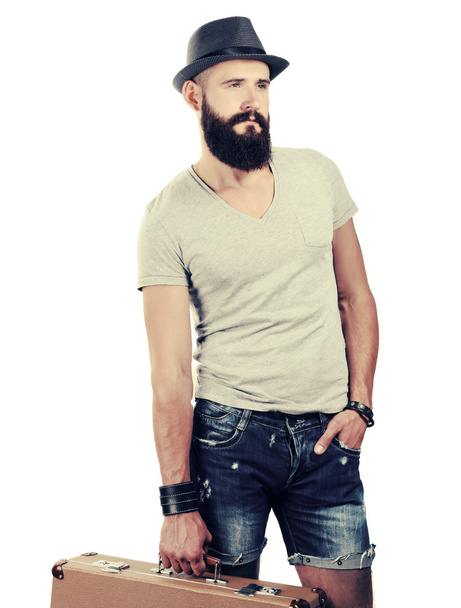 Portrait of handsome bearded man in hat standing with bad, isolated on white background - Foto, immagini