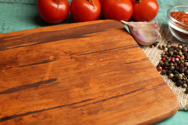 Different spices and herbs with cutting board on color wooden table background - Foto, Imagem