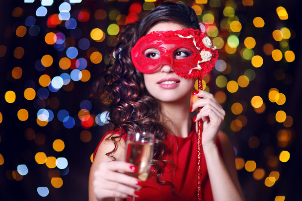 Beautiful girl with masquerade mask and glass of champagne on bright background - Photo, Image