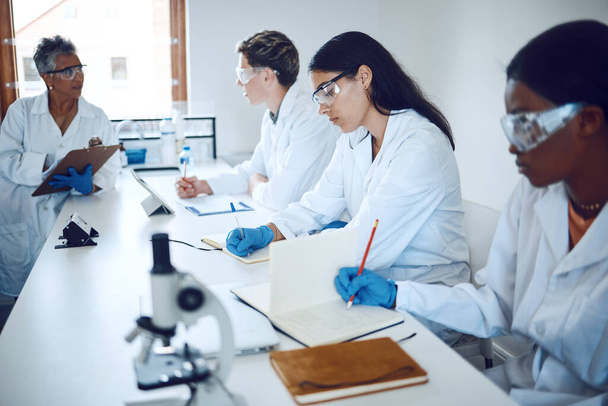 Science team, collaboration and medical students or expert research analysis for healthcare. Education, professor teaching and brainstorming for laboratory analytics or planning strategy innovation. - Photo, Image