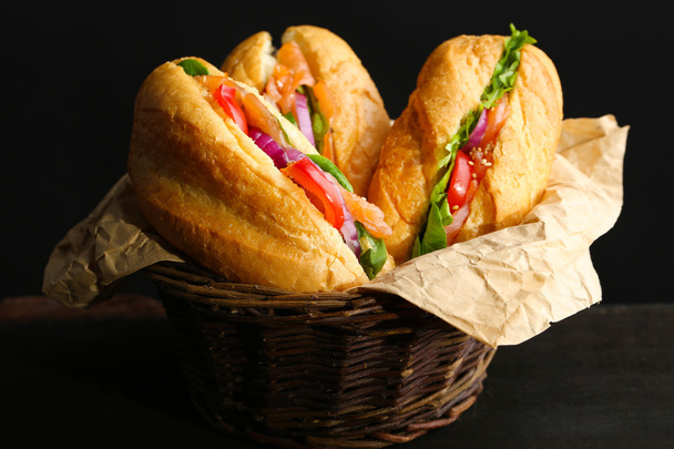 Sandwiches with salmon in wicker basket, on dark background - Fotografie, Obrázek