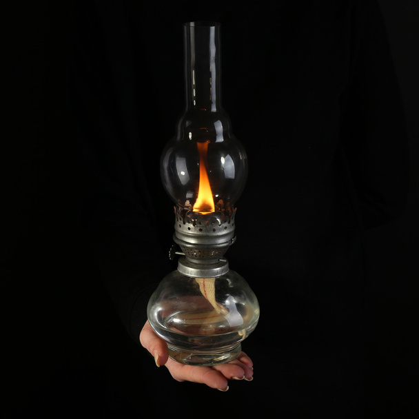 Kerosene lamp in female hands on dark background - Foto, imagen