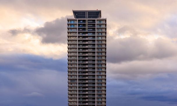 Dramáticas nubes detrás de la torre de apartamentos al atardecer. Foto de alta calidad - Foto, Imagen