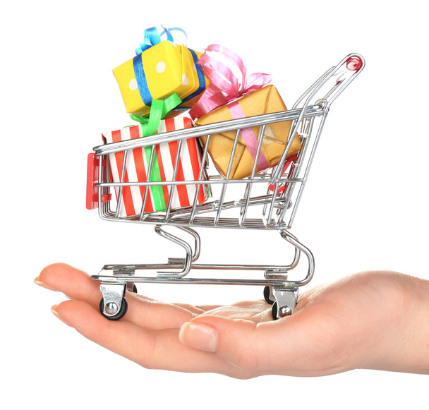 Female hand with small shopping cart full of gifts, isolated on white - Foto, Imagem