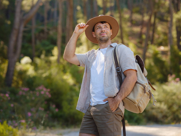 koncepcja przyjmowania świeżego powietrza i angażowania się w działania na świeżym powietrzu. Człowiek Podróżnik z plecakiem i kapelusz wędrówki w górach lasu. Podróże Koncepcja letniego stylu życia. - Zdjęcie, obraz
