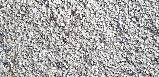 Small white and gray or grey gravel, rock or stone on the floor for background. Hard material, Art or natural wallpaper and Group of object concept - Photo, Image