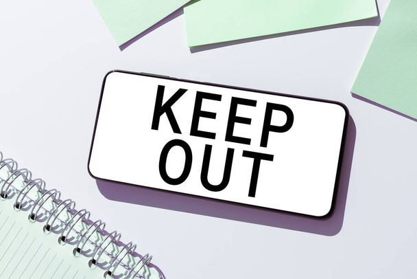 Znak tekstowy pokazujący Keep Out, Concept oznaczający powstrzymanie kogoś lub czegoś przed wejściem w miejsce Znak zagrożenia - Zdjęcie, obraz