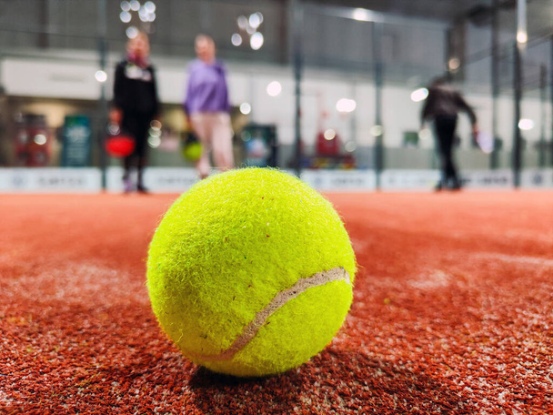 Yksityiskohta laukaus meloa pallo lattialla sisätiloissa meloa tenniskenttä ja kolme pelaajaa ystäviä taustalla tuomioistuin - Valokuva, kuva