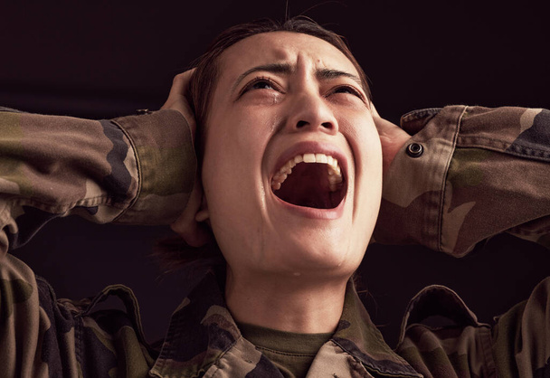 PTSD, crying and trauma with a woman soldier shouting or screaming in studio on a dark background. Scream, grief and tears with a young army female suffering from military memories of war or pain. - Fotó, kép