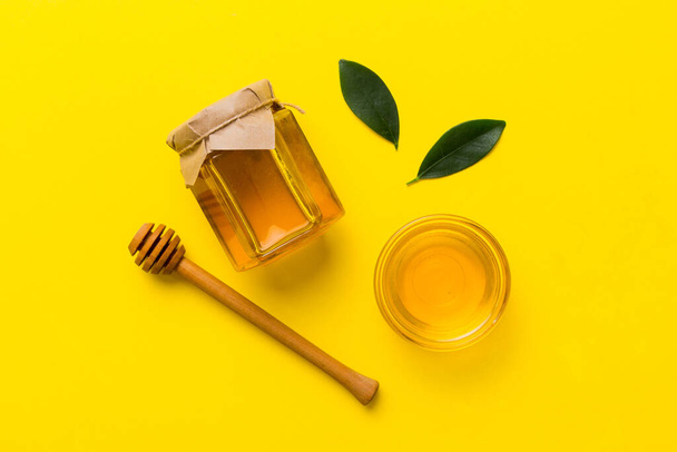 Barattolo di miele con scanalatore di miele in legno su sfondo bianco vista dall'alto con spazio copia. Deliziosa bottiglia di miele. - Foto, immagini