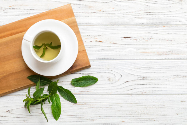 Tasse de thé à la menthe sur fond de table. Thé vert avec vue sur le dessus de menthe fraîche avec espace de copie. - Photo, image