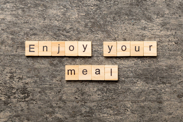 Enjoy your meal word written on wood block. Enjoy your meal text on cement table for your desing, concept. - Photo, Image