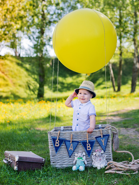 menino em uma cesta com balão
 - Foto, Imagem