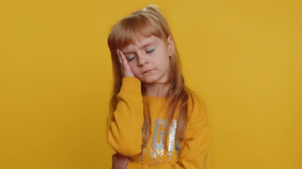 Nespokojené dítě, které si tře spánky, aby vyléčilo problémy s bolestí hlavy, trpí napětím, migrénou, stresem, šklebí se bolestí unavenou studijním vzděláním. Malé batole děti na žlutém pozadí - Záběry, video