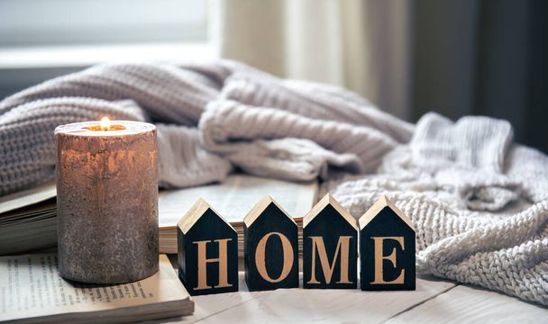 Samenstelling met decoratieve woord huis en kaars op wazig achtergrond, home comfort concept. - Foto, afbeelding
