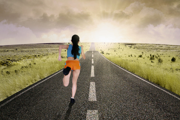Female runner running at road - Fotografie, Obrázek