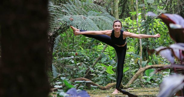 Йоги женщина, тренирующая баланс йоги и саны, позирует на открытом воздухе в природе - Фото, изображение