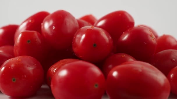 Rotação de tomates cereja vermelhos em um fundo branco. Rotação de tomates cereja maduros. Imagens 4k de alta qualidade - Filmagem, Vídeo