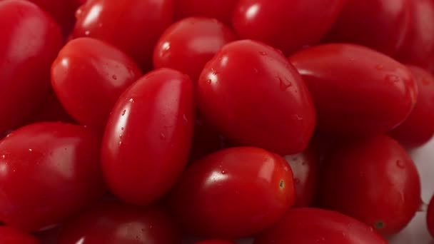 Rotação de tomates cereja vermelhos em um fundo branco. Rotação de tomates cereja maduros. Imagens 4k de alta qualidade - Filmagem, Vídeo