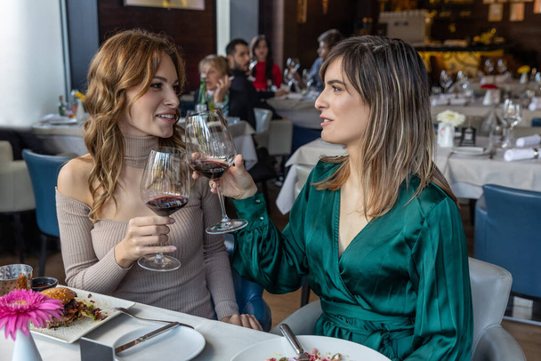 Girlfriends toasting with wine in the restaurant - Фото, зображення