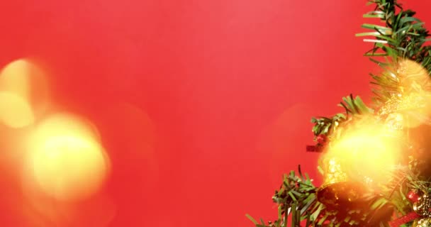 Vrolijk kerstfeest. Kerstboom versierd met kerstversiering op rode achtergrond met bokeh lichten. - Video