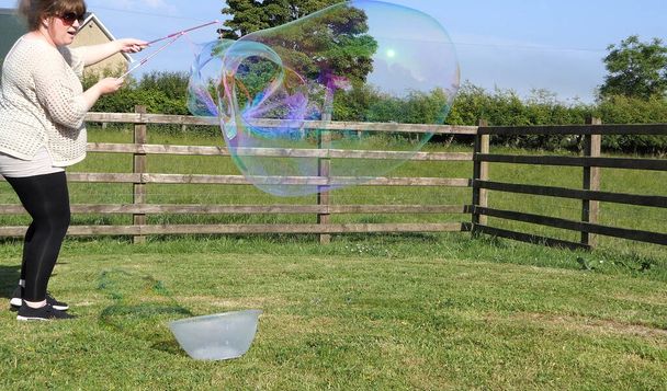 Giant Zeep Bubble met een Bubble wand in een tuin - Foto, afbeelding