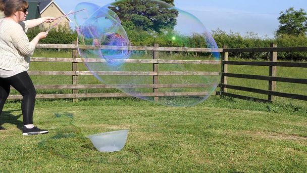 Гигантский мыльный пузырь с пузырем в саду - Фото, изображение