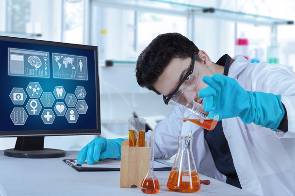 Scientist pouring chemical in test tube - Foto, Bild