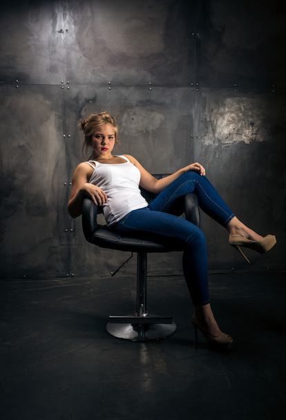 seductive woman sitting on chair at dark grungy room - Foto, Bild