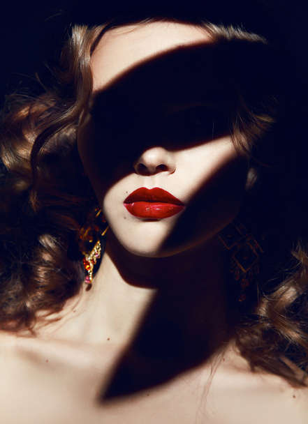Beautiful blonde curly hair makeup red lips in the shadows - Φωτογραφία, εικόνα