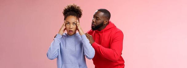 Man apologizing girlfriend behind back touching shoulder comforting girl feel pressured irritated fed up lying hear boyfriend sorry arguing standing bothered pink background, couple fighting. - Photo, Image