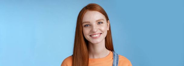 Cheerful lively redhead caucasian girl smiling happily look camera kind sincere friendly talking have perfect summer holidays talking friends standing blue background joyful. Copy space - Photo, Image