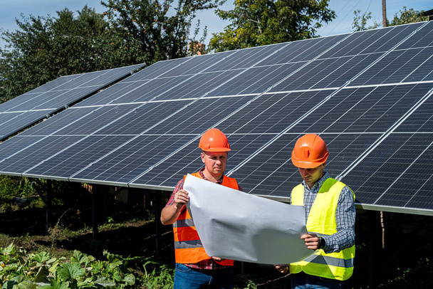 Dois engenheiros plano de discussão para encontrar problemas solares painéis fotovoltaicos, trabalho em equipe - Foto, Imagem